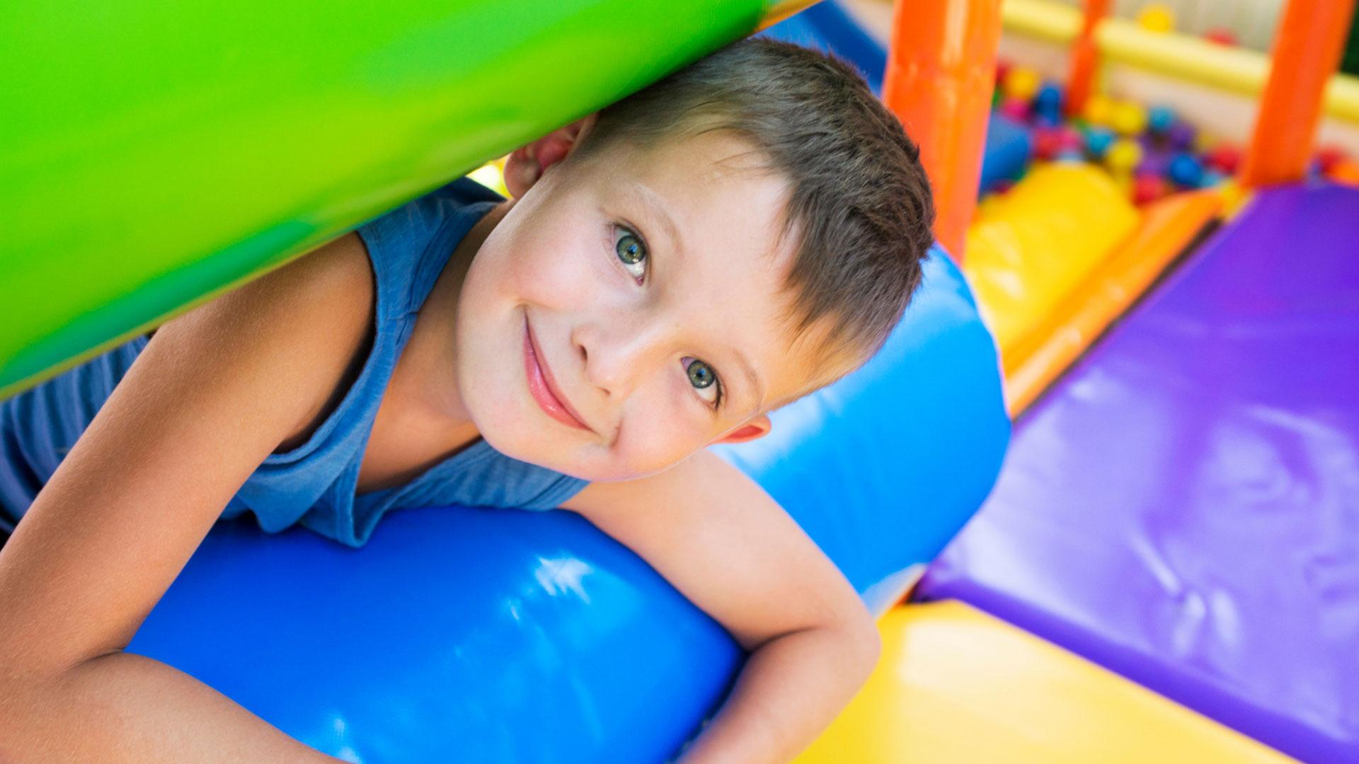 Smiling child in a colorful inflatable playground.
