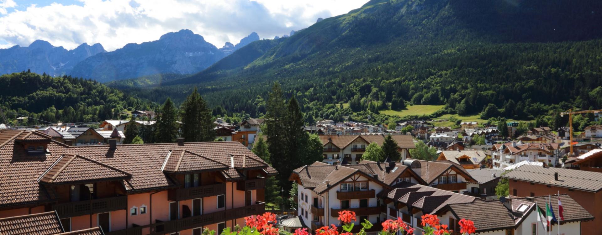 Vista panoramica di un villaggio alpino con montagne sullo sfondo.