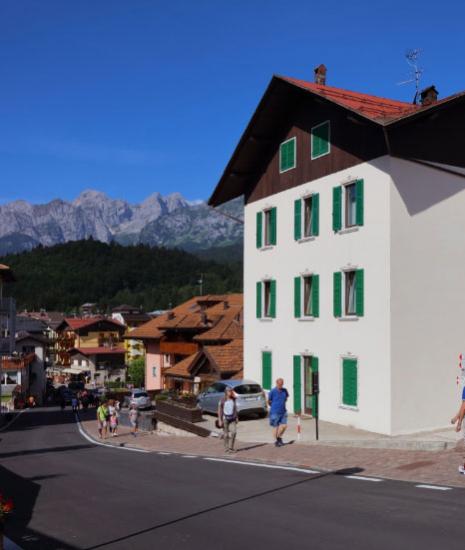 Mountain village with houses and roads, mountains in the background.