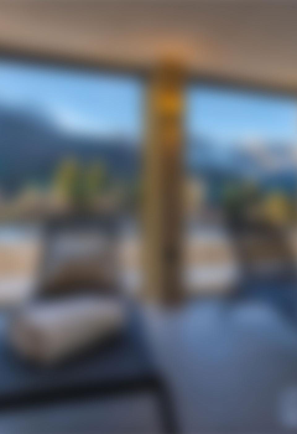 Panoramic mountain view from a room with large windows.